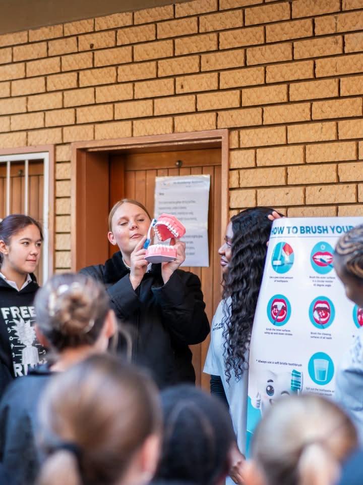 IA Academy learner demonstrating tooth brushing technique with Smile Haven, July 2026