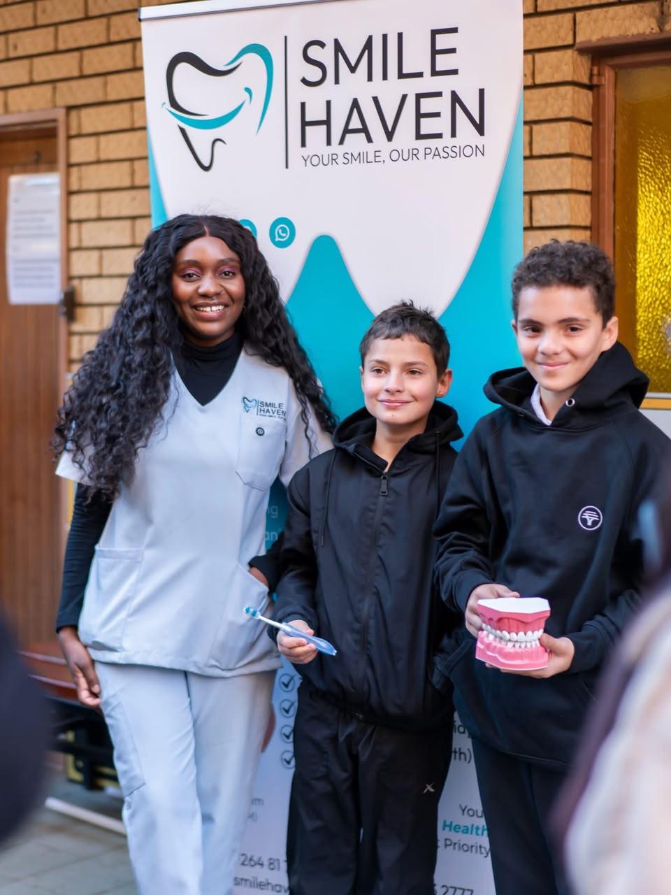 Smile Haven team member with IA Academy learners and a dental model, July 2026
